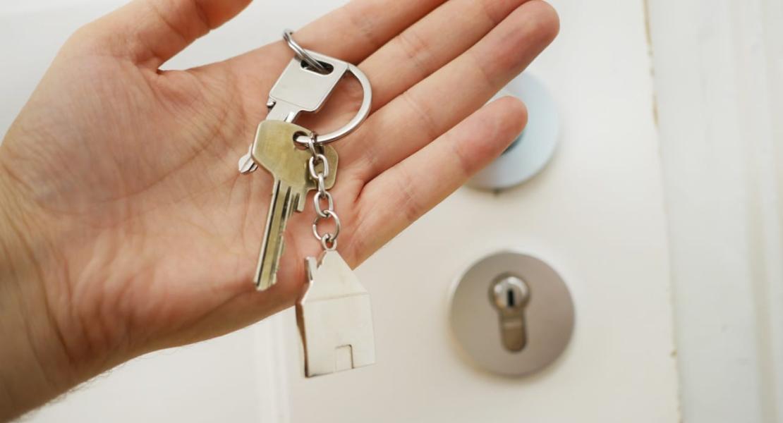 Hand holding keys near door lock